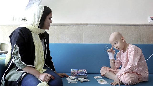 Laya Taghizadeh plays cards with her eight-year-old son in the hospital 