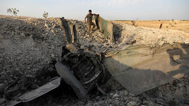המורדים סוריה עם שברי המטוס מטוס אידליב  חאן שייחון   (צילום: AFP)