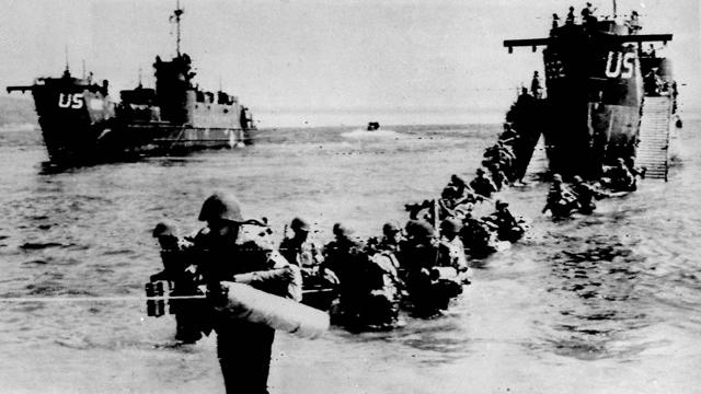 American and allied troops wade through the water from a Landing Ship Tank on an unidentified beach, east of Toulon, southern French riviera, as part of Operation Dragoon, August 16, 1944  
