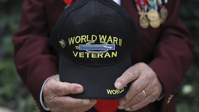 Harold Radish, 95, of the 90th division and a prisoner of war, holds his cap