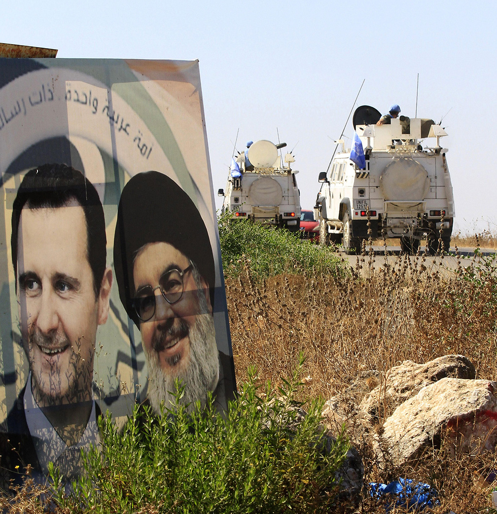 UN peacekeepers in south Lebanon drive past a poster of Hezbollah chief Hassan Nasrallah and Syrian President Bashar Assad (Photo: AFP)