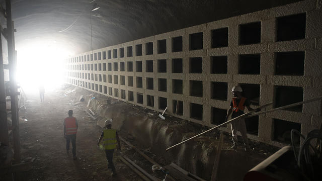 Workers walk at the construction site of a massive underground cemetery in Jerusalem, August 18, 2019  
