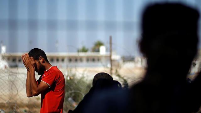 A Palestinian man waits for a travel permit  (Photo: Reuters)