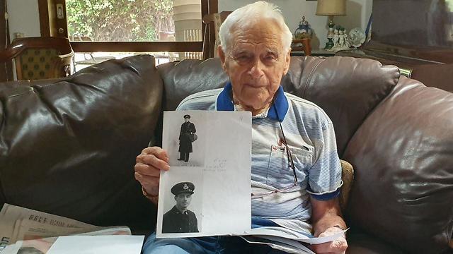 אלכס זילוני בן ה-103, בדירתו בתל אביב, עם תמונה שלו במדי חיל האוויר המלכותי ()