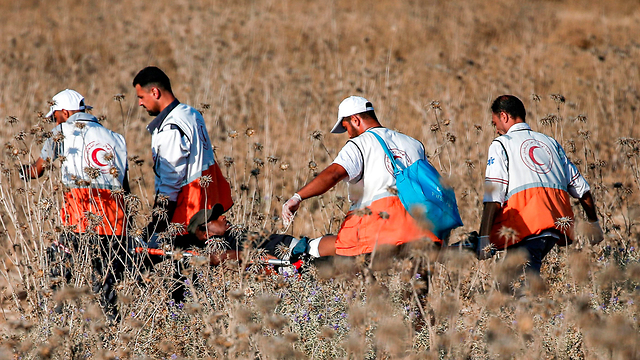 Palestinian medics evacuating the wounded during clashes with IDF troops on the Gaza border Friday (Photo: AFP)