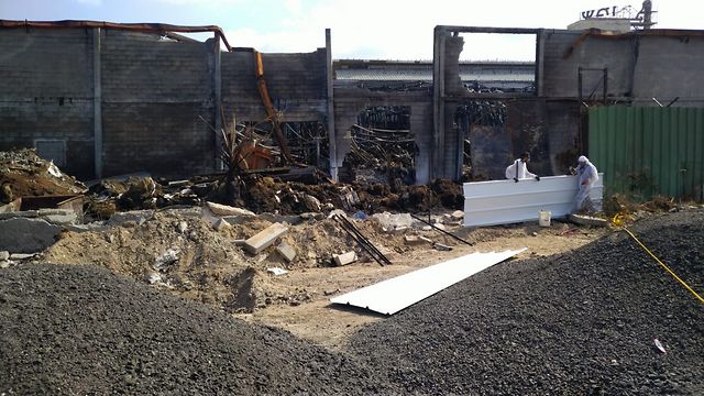 עובדיו של הקבלן שמפנה את האזבסט, החלו היום בהקמת גדר באזורים בהם נשברה גדר המפעל במהלך השריפה (צילום: דוברות המשרד להגנת הסביבה)