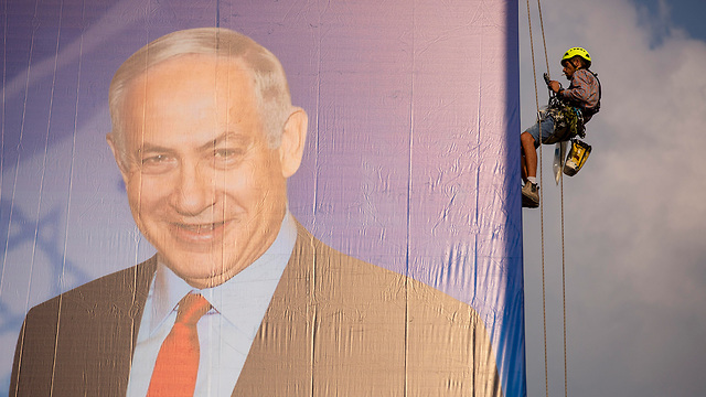 Netanyahu's election billboard being put up in Tel Aviv (Photo: AP)