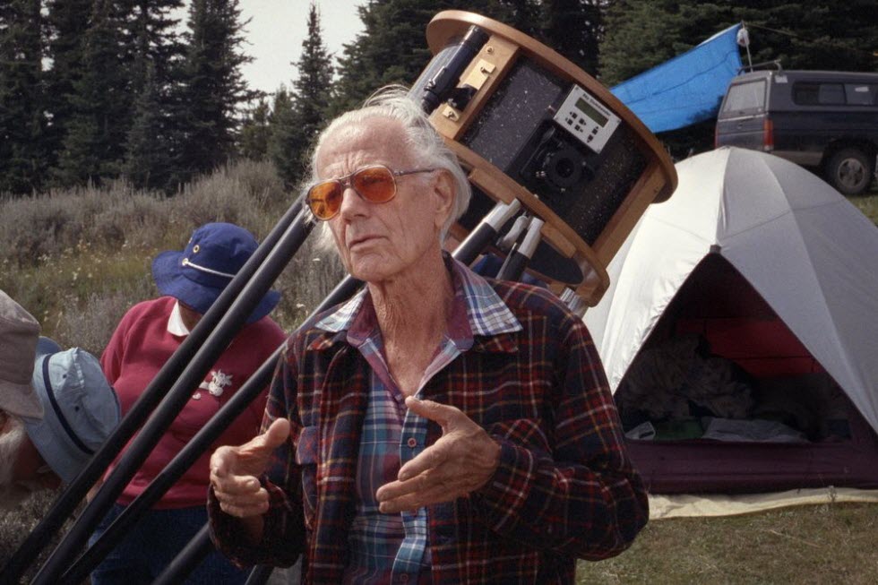 ג'ון דובסון על רקע טלסקופ מקצועי שנבנה בהשראתו.  (צילום: אתר ארגון 