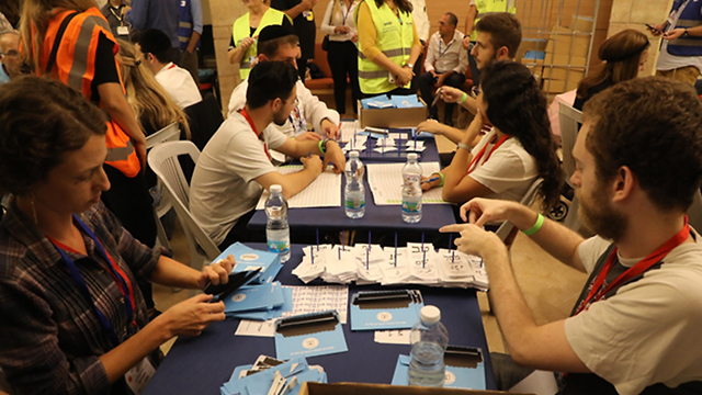 Central Elections Committee staffers count the double envelopes from Tuesday's ballot (Photo: Yitzhak Harari)