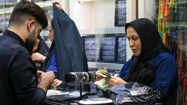 An Iranian woman counts Iranian rials at a shop (Photo: Reuters)
