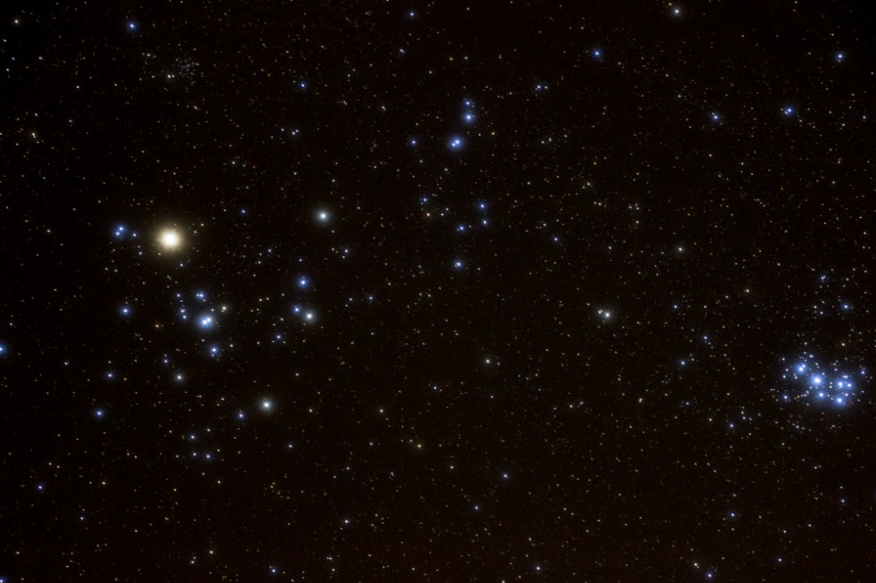 צביר הפליאדות (מימין) וצביר ההיאדות (משמאל). הכוכב האדמדם הוא אלדברן, עינו הזועמת של השור.  (צילום: Genevieve de Messieres)