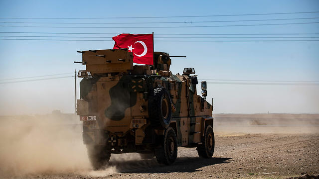 A Turkish military vehicle drives on a joint patrol with US troops in the Syrian village of al-Hashisha on the outskirts of Tal Abyad town on the border with Turkey