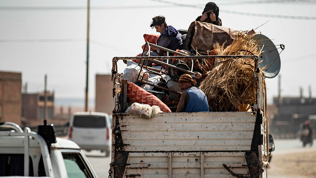 תושבים כורדים מתפנים לאחר התקיפה הטורקית בצפון מזרח סוריה (צילום: AFP)