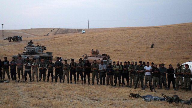 חיילים של צבא טורקיה עם מורדים סורים מחוץ לעיר הכורדית מנביג' סוריה (צילום: AFP)