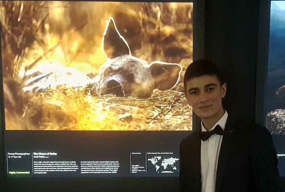 אריאל פילדס בתערוכה במוזיאון הטבע בלונדון לצד הצילום שזכה לציון לשבח (צילום: אנטוני פילדס)