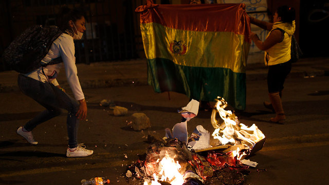 בוליביה בחירות מהומות פעילי אופוזיציה מציתים כרזות של מפלגת השלטון לה פאס (צילום: AP)
