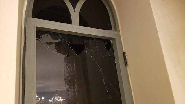החלון שהתנפץ בסלון הבית לאחר הירי ()