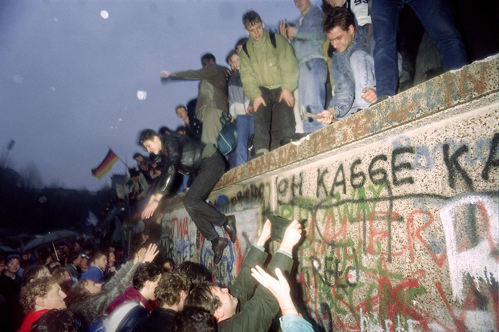אנשים במערב ברלין מול שבר בחומה ומהצד השני חיילים ממזרח ברלין (צילום: AFP)