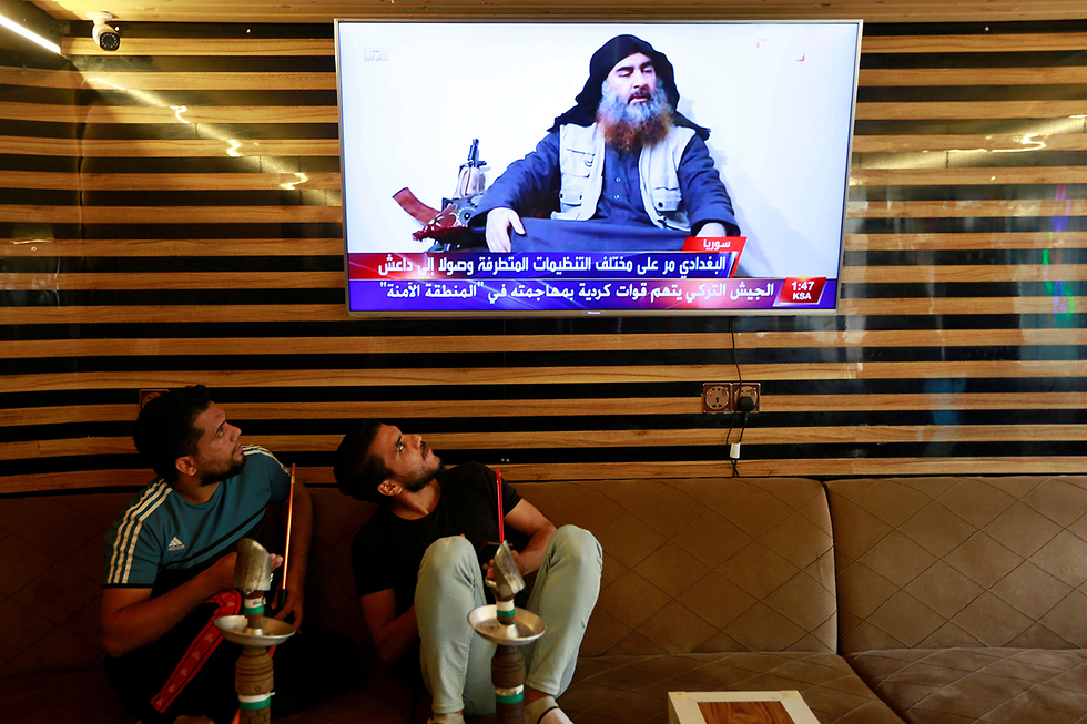 צעירים ב נג'ף עיראק צופים בחדשות על חיסול מנהיג דאעש אבו בכר אל-בגדדי (צילום: רויטרס)