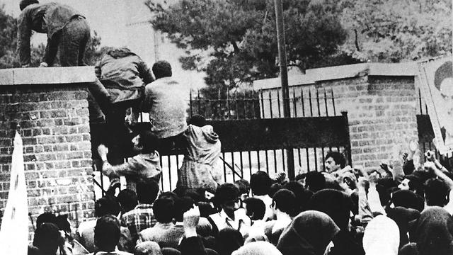Iranian revolutionary students climb the U.S. embassy's gate in Tehran, Nov. 4, 1979