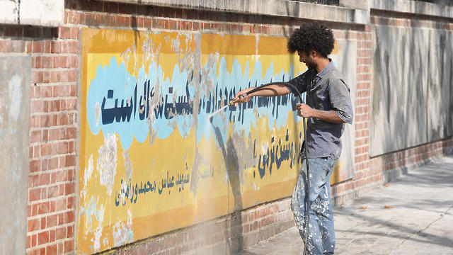 A worker uses a water jet cleaner to erase a mural painting on the wall of the former U.S. embassy in Tehran, Sept. 29, 2019