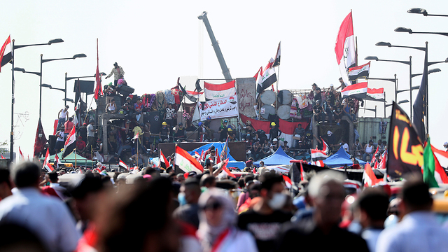 עיראק מפגינים עומדים על מחסומים שהקים הצבא בגדד (צילום: AP)