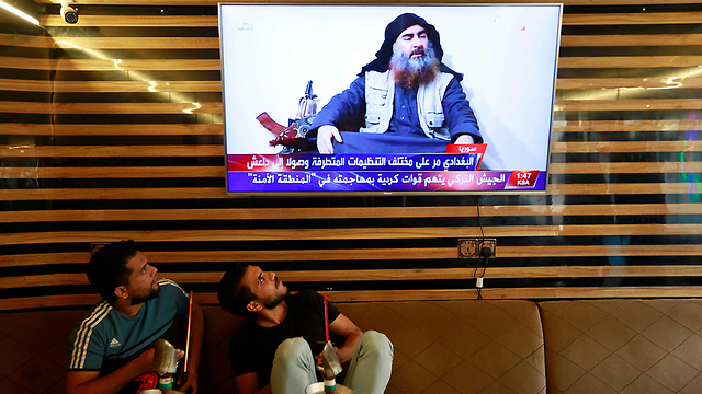 צעירים ב נג'ף עיראק צופים בחדשות על חיסול מנהיג דאעש אבו בכר אל-בגדדי (Photo: Reuters)