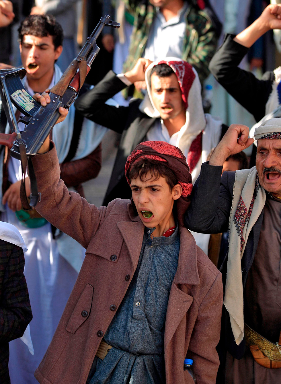 נער תומך צעיר של ה חות'ים ב צנעא תימן מניף רובה קלצ'ניקוב קלשניקוב (צילום: AFP)