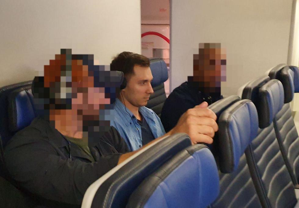 Алексей Бурков в окружении агентов ФБР во время экстрадиции в США. Фото:  Ynet 