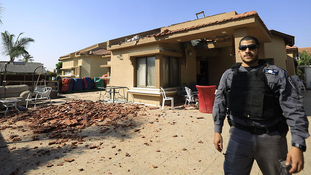 A policeman stands in front of a house hit by a Gaza rocket in the southern town of Netivot, Nov. 12 2019 