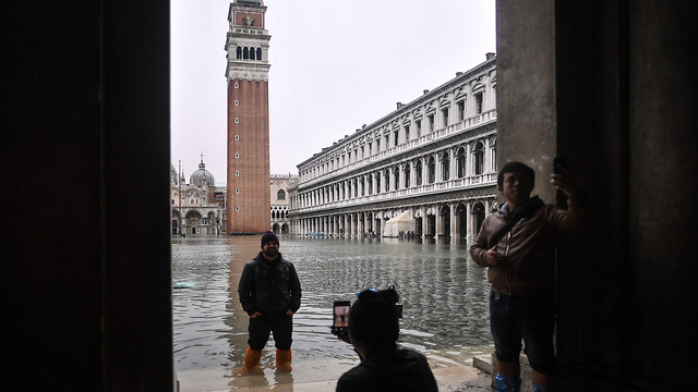 Tourists watch venice flooded (Photo: AFP)