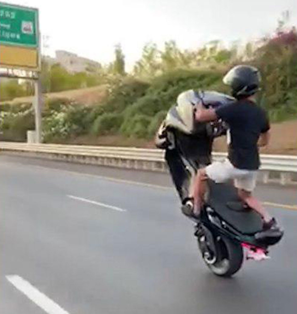 תיעוד: רוכב אופנוע מבצע הרמת גלגל קדמי תוך כדי נסיעה מהירה ()