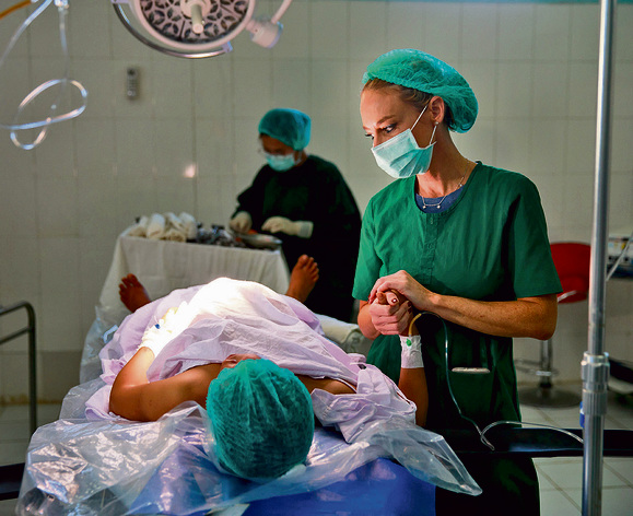 ד"ר אלמוג מחזיקה יד ליולדת לפני ניתוח קיסרי בבורמה | צילום: זיו קורן