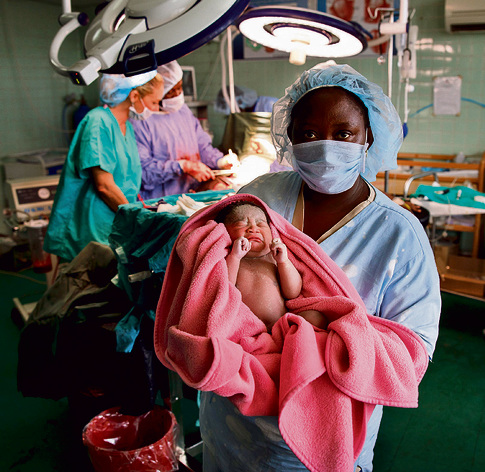 תינוק יוצא לאוויר העולם. חדר לידה בליבריה | צילום: זיו קורן