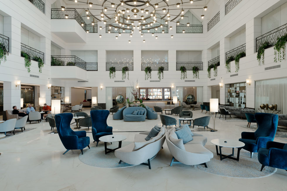 הלובי העצום של המלון החדש, בעיצוב משרד האדריכלים רן ומוריס. חדרי הקומה הראשונה משקיפים פנימה. הצמחייה מלאכותית (צילום: גדעון לוין – סטודיו 181)