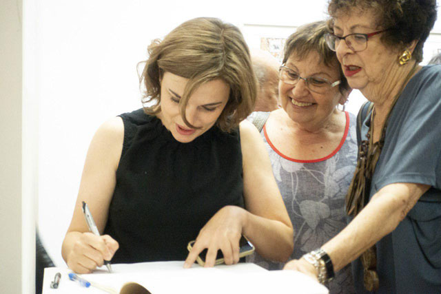 Дорошева подписывает работы на выставке. Фото: личный архив