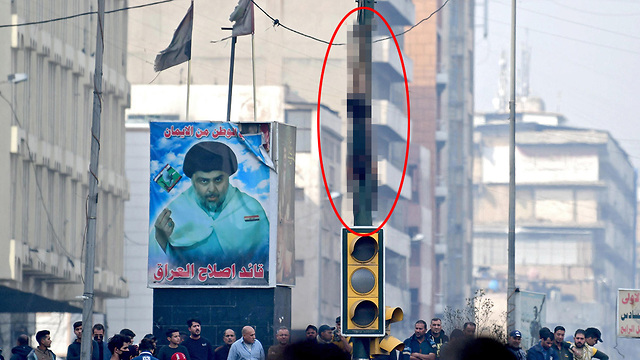 עיראק בגדד מחאה נער רצח מפגינים נתלה על רמזור (צילום: EPA)