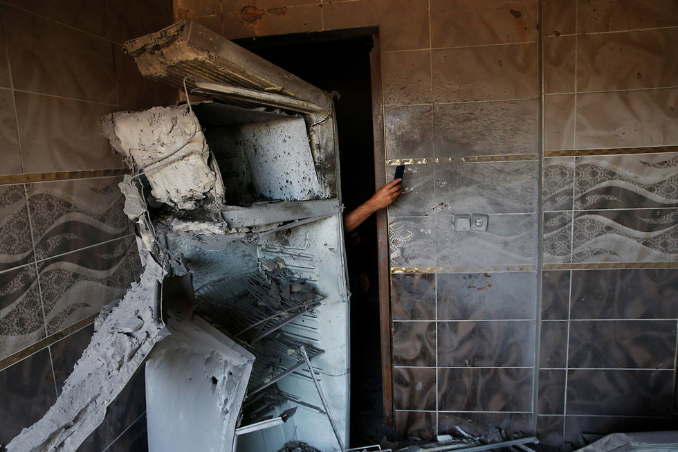 תמונות השנה AP טורקי בעיירה בגבול סוריה מצלם את הבית שנפגע מפצצות מרגמה (צילום: AP)