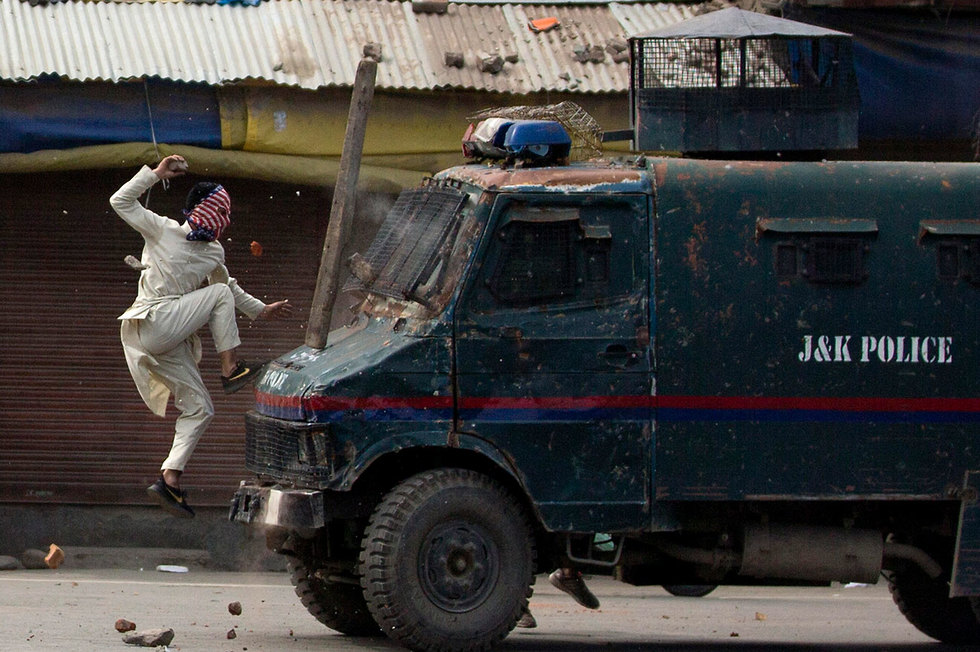 תמונות השנה AP מפגין רעול פנים משליך אבנים על רכב משטרתי משוריין חבל קשמיר הודו (צילום: AP)