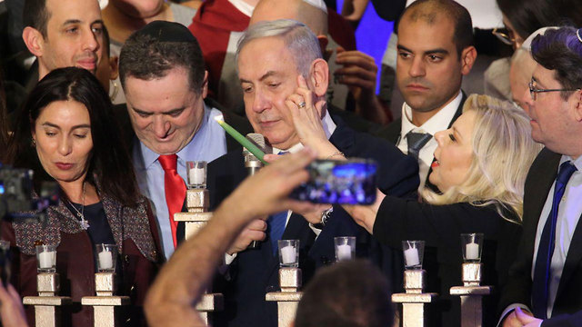 Биньямин Нетаниягу зажигает ханукальную свечу с активистами Ликуда. Фото: Моти Кимхи
