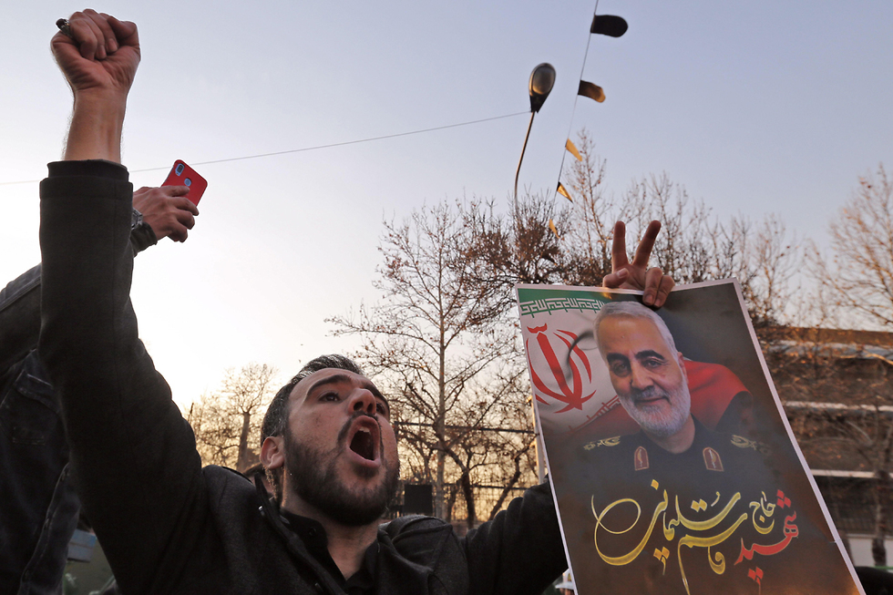 מפגינים שורפים דגלי ישראל ו בריטניה מול שגרירות בריטניה ב טהרן איראן (צילום: AFP)