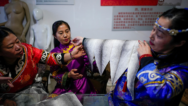 סין האנשים שלובשים דגים (צילום: רויטרס)