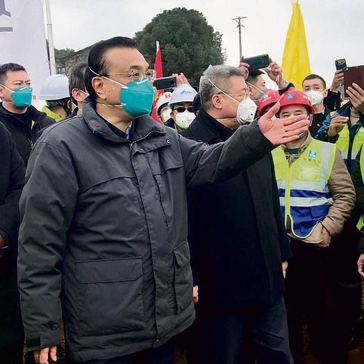 ראש ממשלת סין עם מסכת הגנה בביקור בעיר | צילום: EPA