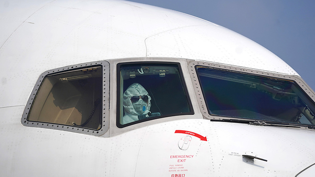 טייס מטוס מטען עם מסיכה ב ווהאן סין  (צילום: AP)