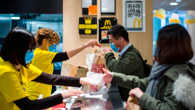 לקוחות ועובדים ב מקדונלדס עם מסיכות  (צילום: AFP)