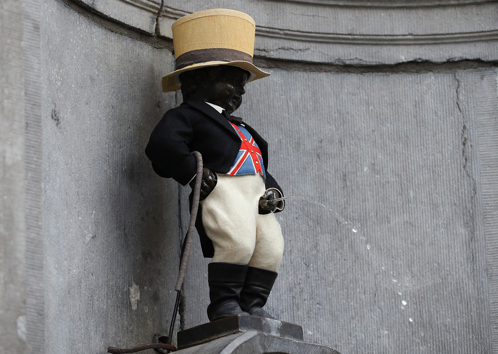פסל הילד המשתין מאנקן פיס ב בריסל לבוש ב דגל בריטניה ברקזיט (צילום: MCT)