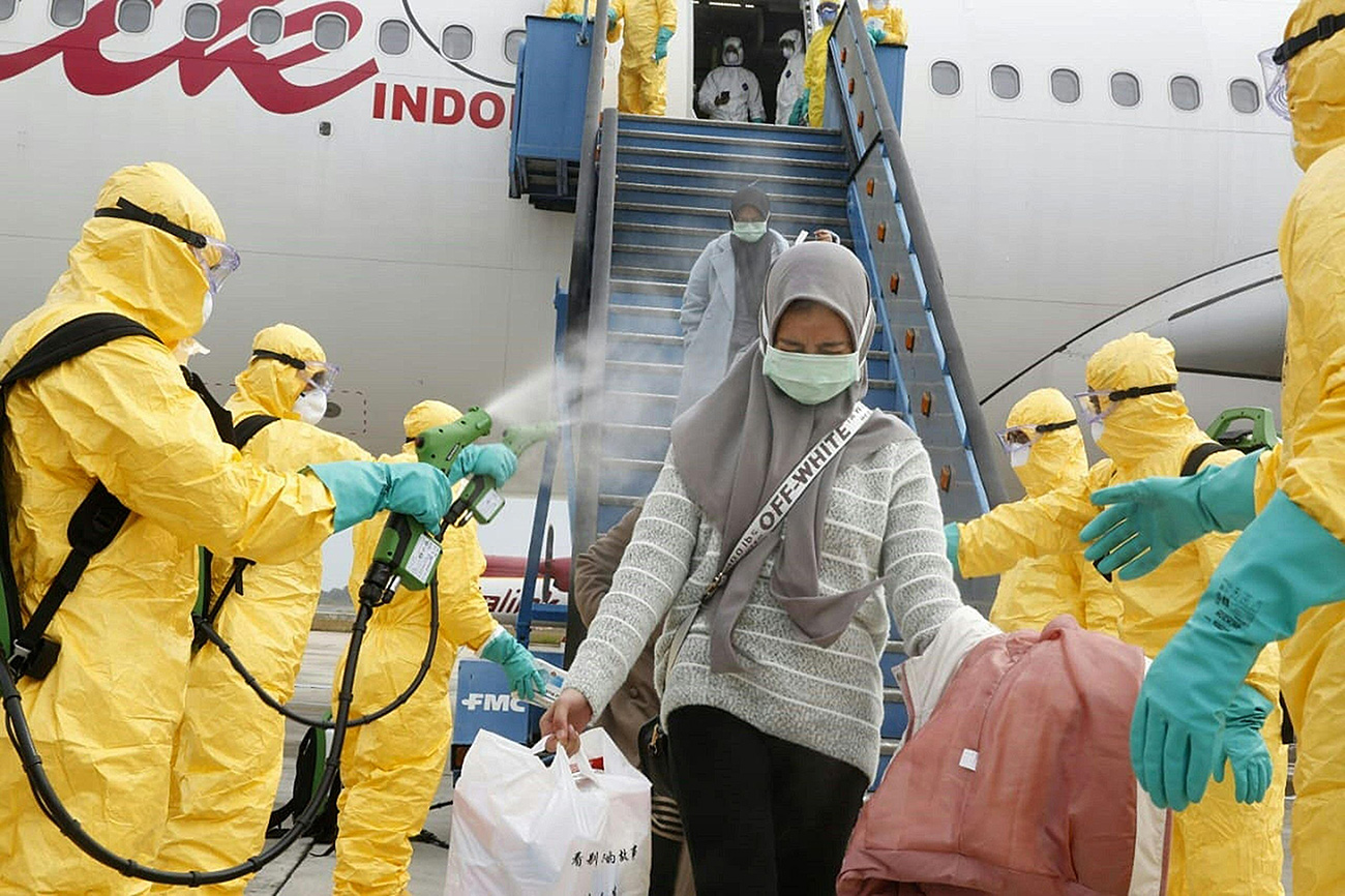 Индонезийские студенты, проходившие обучение в Уханe, подвергаются дезинфекции при эвакуации на родину. Фото: AFP
