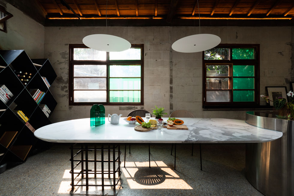 שולחן האוכל מורכב מפלטת שיש על רגליים מרושלות כביכול, מברזל בניין חלוד (צילום: JC Architecture)