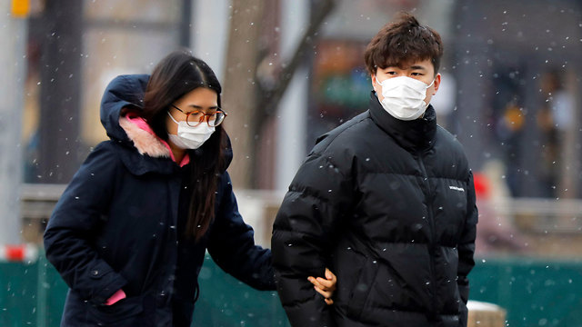 נגיף וירוס קורונה אנשים לובשים מסכות ההולכות ברחוב בבייג'ינג, סין (צילום: EPA)