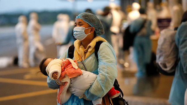 אנשים חוזרים מ ווהאן סין ל וייטנאם (צילום: AFP)